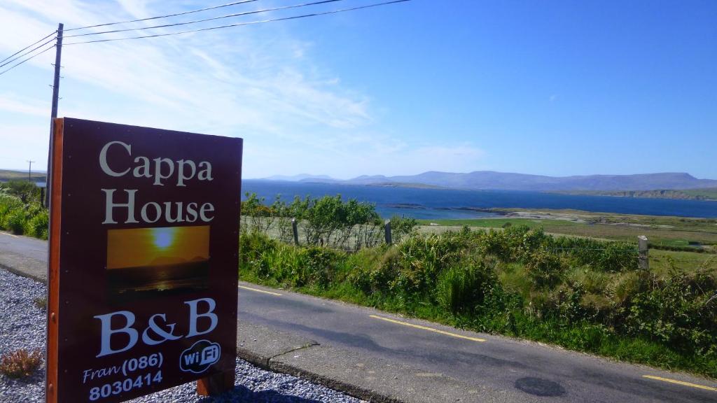 una señal para una casa Capa al lado de una carretera en Cappa House B&B, en Eyeries