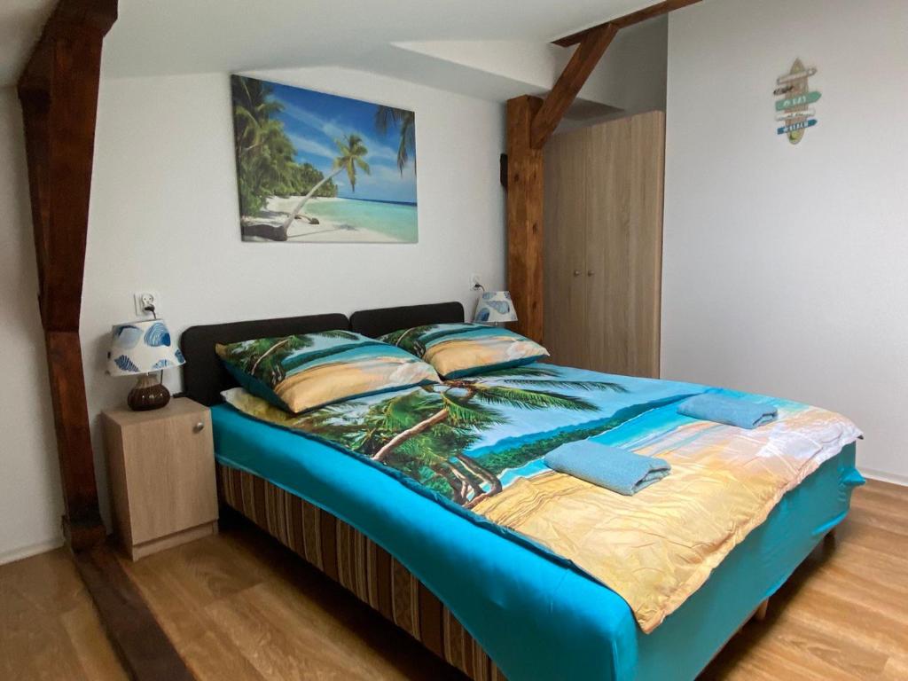 - une chambre dotée d'un grand lit avec des draps et des oreillers bleus dans l'établissement Sea world Apartments Mansarda, à Gdańsk