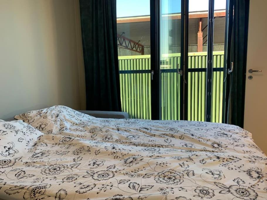 a bed with a blanket on top of it with a window at Central 1 bedroom apartment NB!! Small room in Oslo
