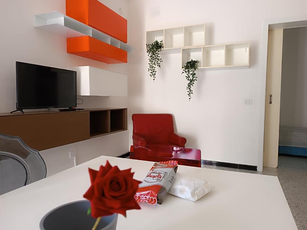 a living room with a table and a red chair at Appartamento Azzurra in Melendugno