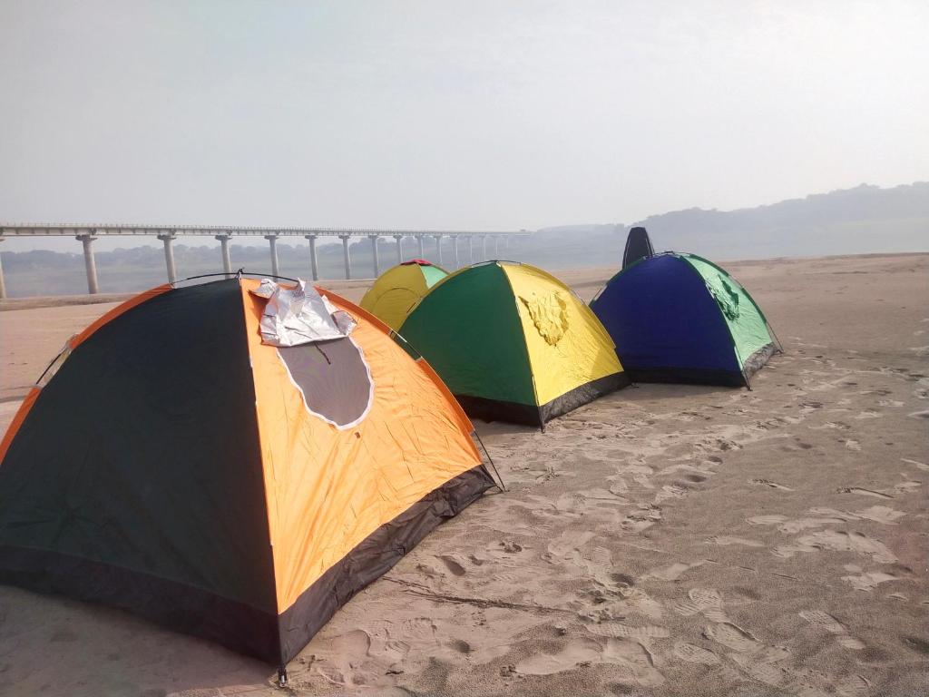 a group of three tents sitting on the beach at Jhoomke camping and water sports adventure in Auraiya