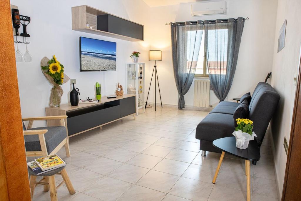 ein Wohnzimmer mit einem Sofa und einem Tisch in der Unterkunft Casa Elisa La Caletta in La Caletta