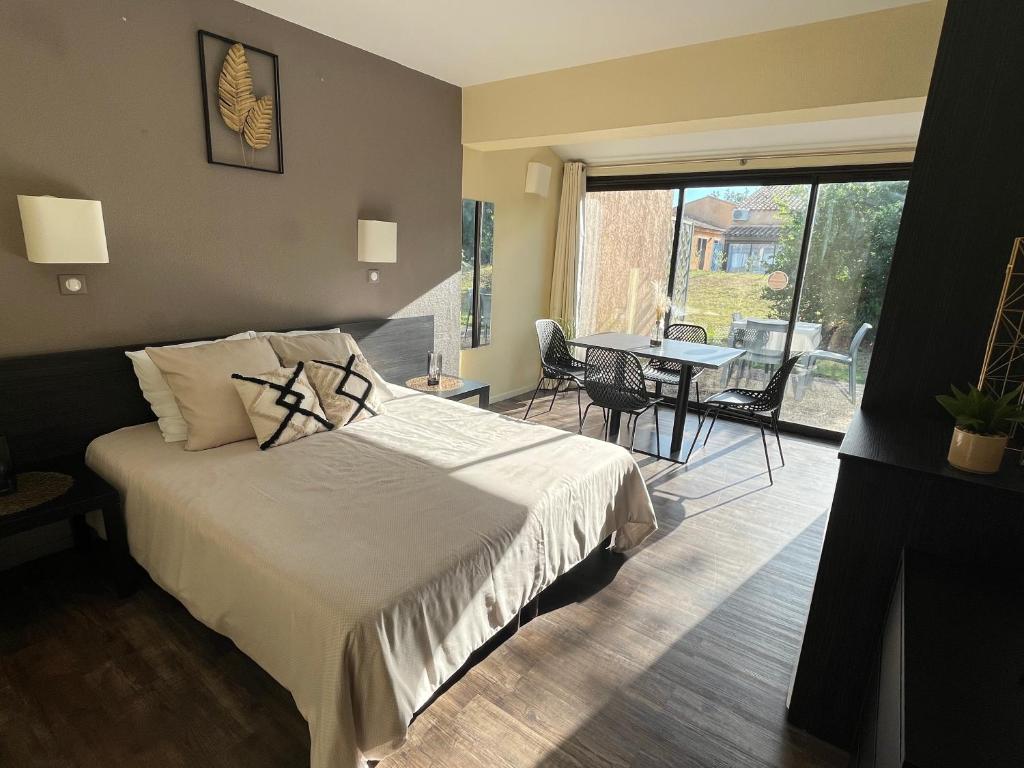 une chambre avec un lit et une table avec des chaises dans l'établissement Studio entre terre et mer - 4 personnes, à Arles