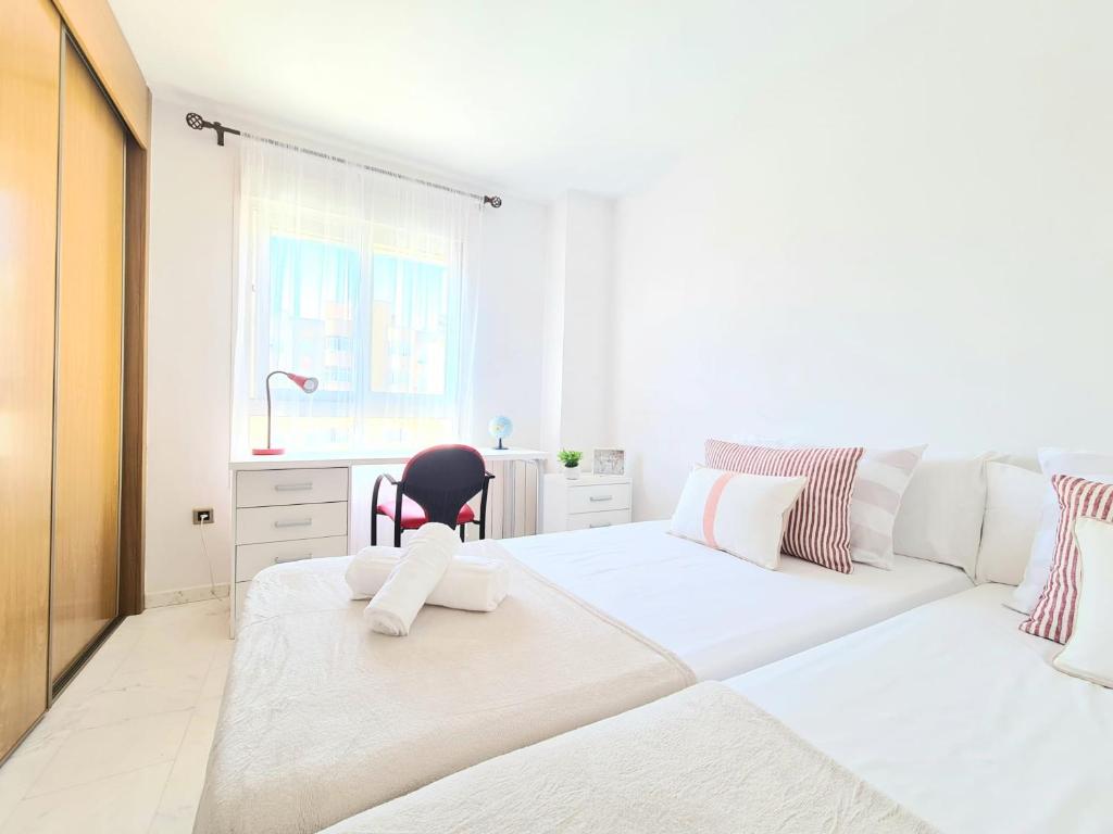 a white bedroom with two beds and a couch at Apartamento 3 dormitorios Malaga (Teatinos) in Málaga