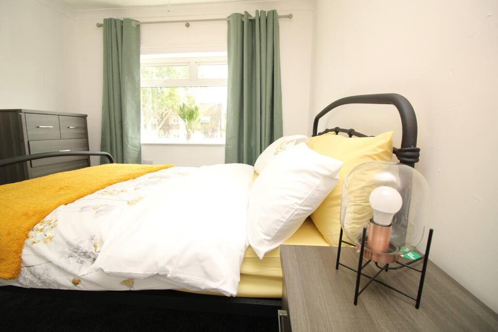 Schlafzimmer mit einem Bett mit weißen und gelben Kissen in der Unterkunft Exceptional 3 Bed, Great Location in Ashby Ideal for Travellers, Short Holiday Stays And Contractors in Brumby