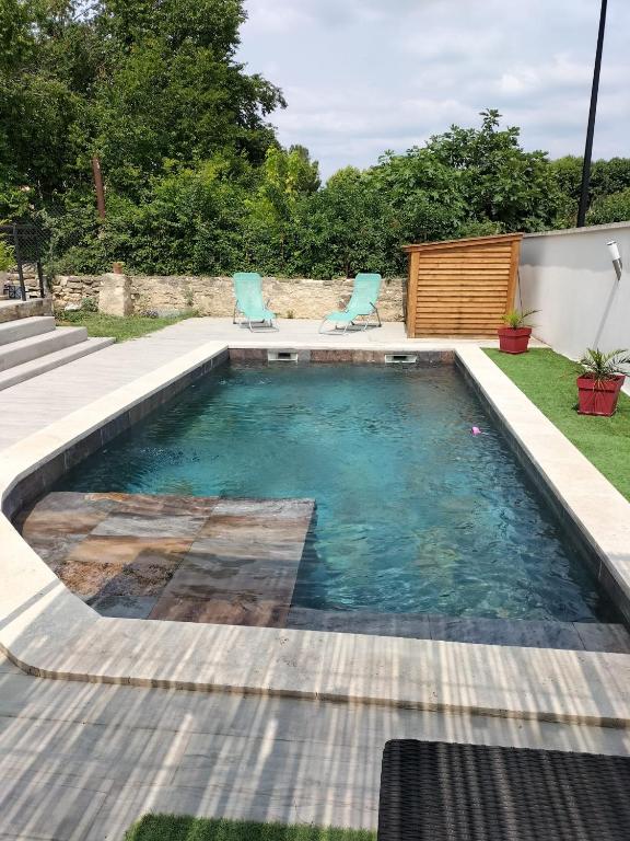 - une piscine avec deux chaises dans la cour dans l'établissement Villa Sofia, à Malemort-du-Comtat