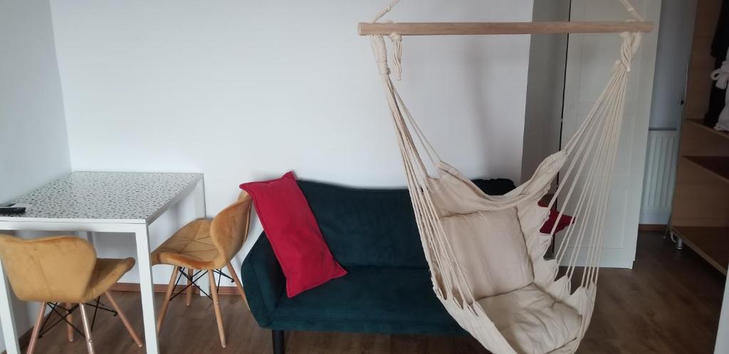 a hammock in a living room with a table and a chair at Private room at Ceausescu's place in Old City Unirii Square in Bucharest