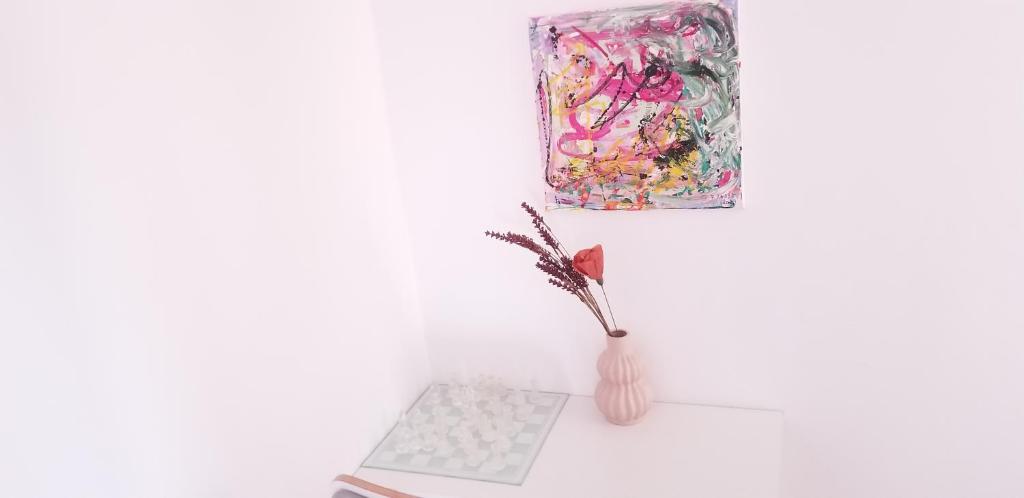 a vase with a plant in it next to a painting at Private room at Ceausescu's place in Old City Unirii Square in Bucharest