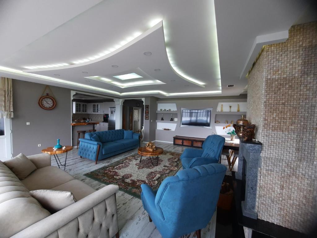 una sala de estar con sofás azules y una mesa. en Aktürk villa, en Trabzon