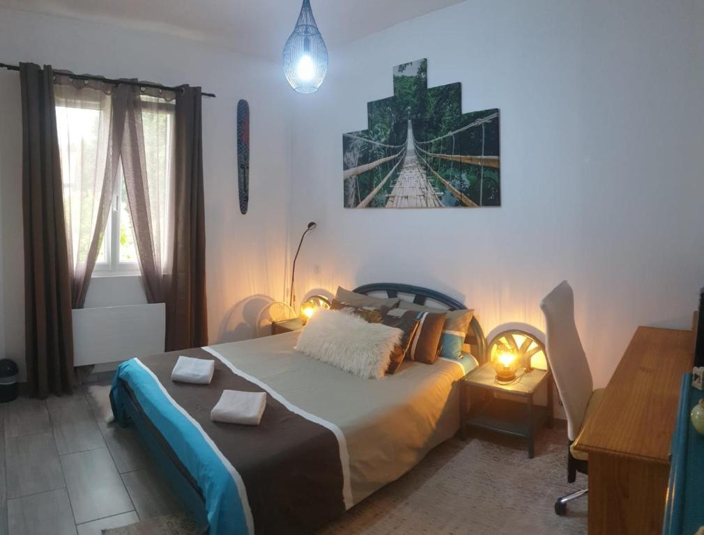 a bedroom with a bed and a desk with lights at Chambre cosy entre mer et montagne in Ascain