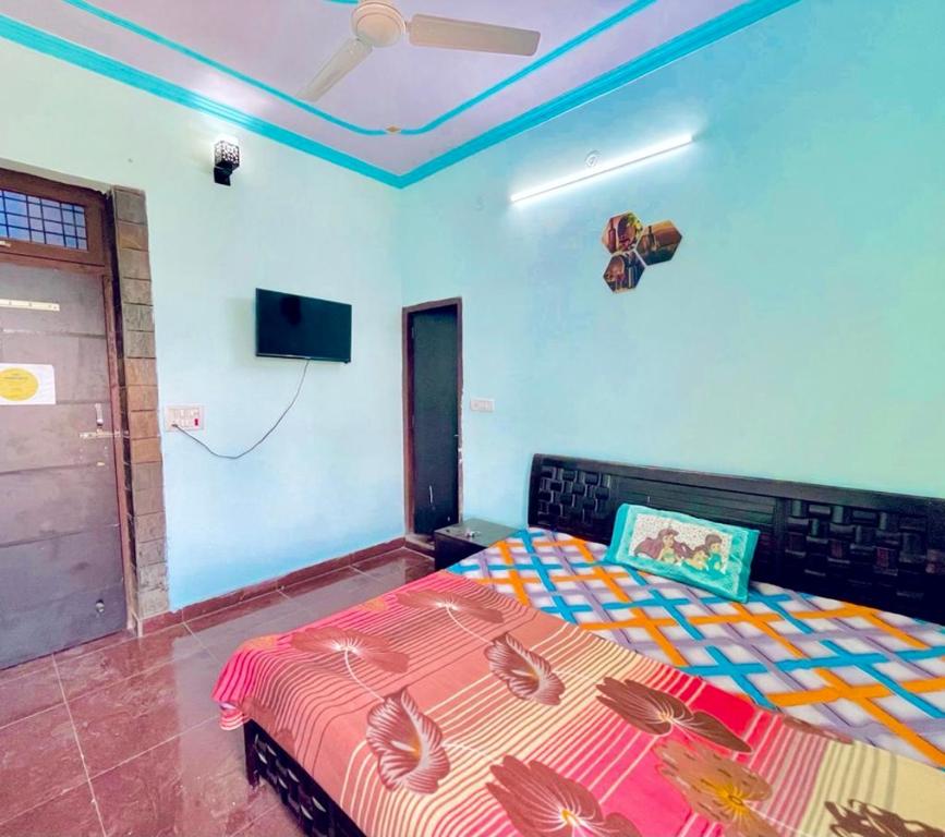 a bedroom with two beds and a flat screen tv at Arihant PG & Rooms in Rewāri