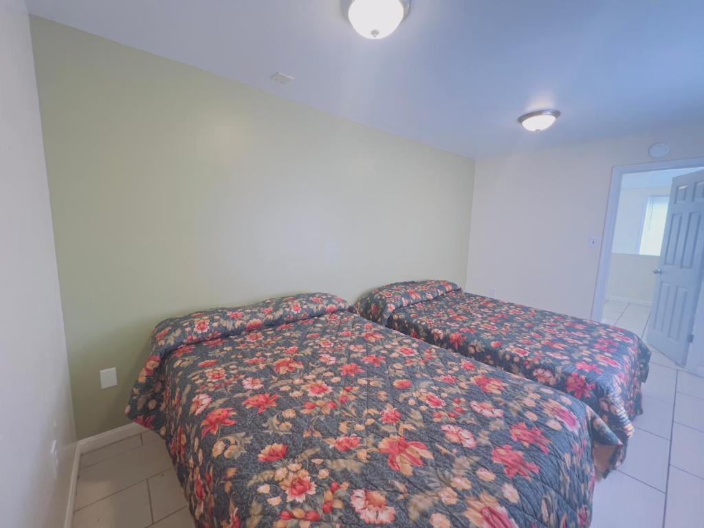 a bedroom with a bed with a floral comforter at Shore Beach Houses - 40 - 1 Dupont Ave in Seaside Heights