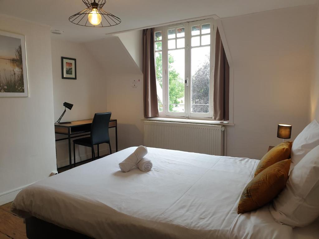 une chambre avec un lit avec un ours en peluche dessus dans l'établissement LE MATIN CALME - Charme ancien - Vue canal, à Dole