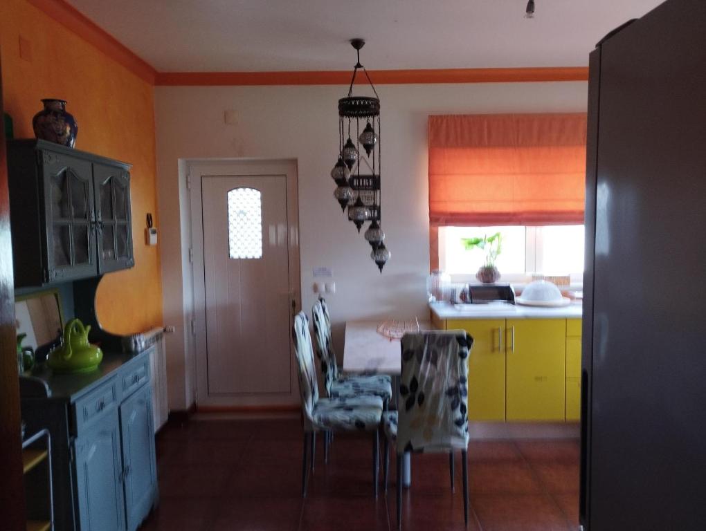 Villa Porto de Mós near Fatima في بورتو دي موس: مطبخ مع طاولة وكراسي في غرفة