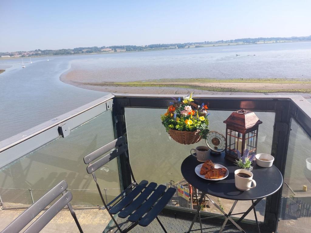 a table and chairs on a balcony with a view of the water at Holiday Let Mistley in Mistley