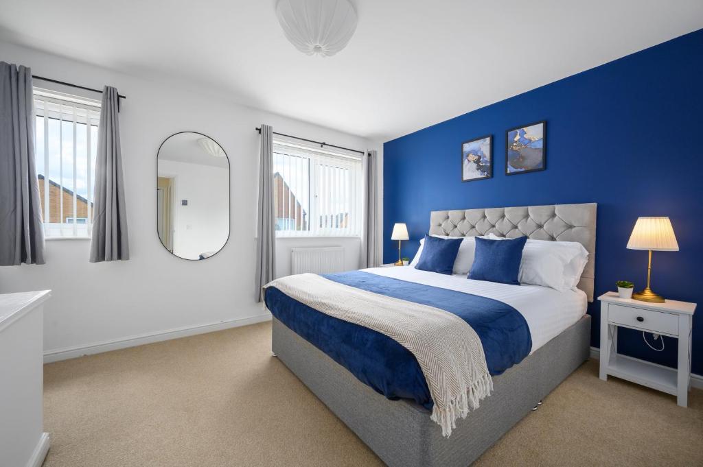 a blue bedroom with a bed and a mirror at Stunning Entire House 6 mins to Manchester City Centre, near Etihad stadium, Free Parking and Super Fast Wifi in Manchester