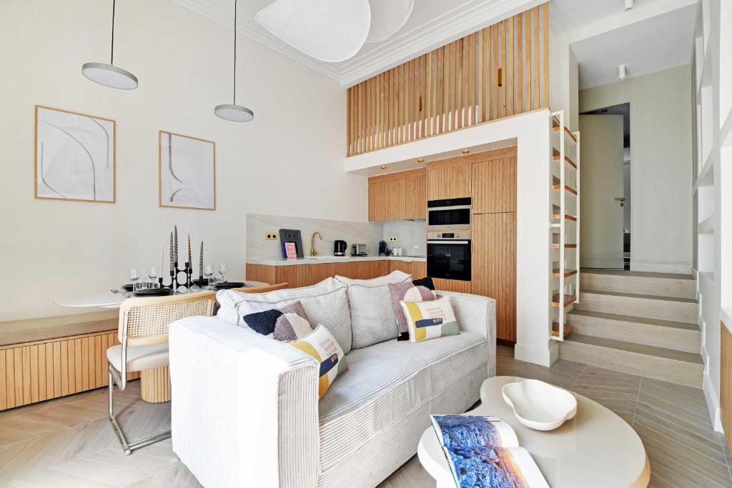 a living room with a white couch and a table at Luxury apartment 5P1BR - Square des Batignolles in Paris