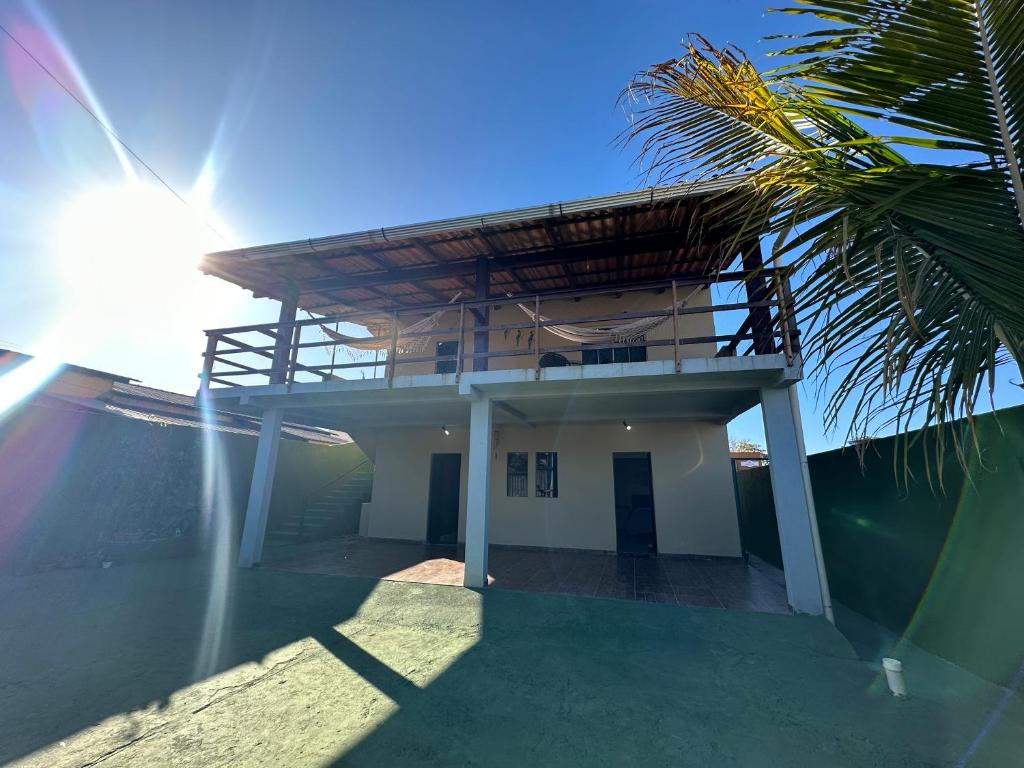 a house with a balcony and a palm tree at Flats Paraíso Dos Ipês in Alto Paraíso de Goiás