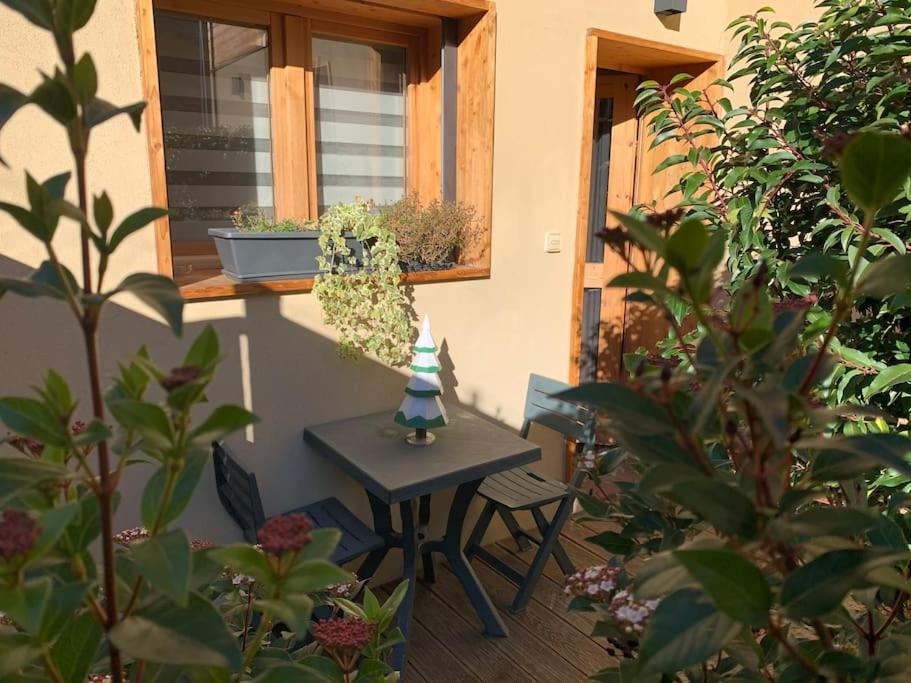 a small table and bench in front of a window at Chaleureux studio plein sud en Tarentaise ! in Bozel