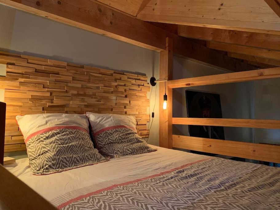 a bedroom with a bed with a wooden wall at Chaleureux studio plein sud en Tarentaise ! in Bozel