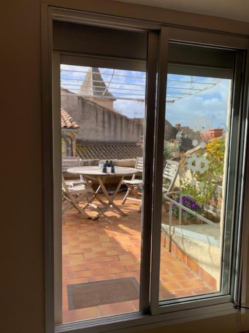 d'une fenêtre donnant sur une terrasse avec une table. dans l'établissement Charmigt byhus med takterass, à Thèzan-lès-Béziers