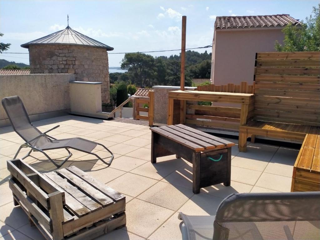 eine Terrasse mit einer Bank, einem Tisch und einem Tisch in der Unterkunft Maison de vacances 4 chambres, jardin et toit terrasse in Peyriac-de-Mer