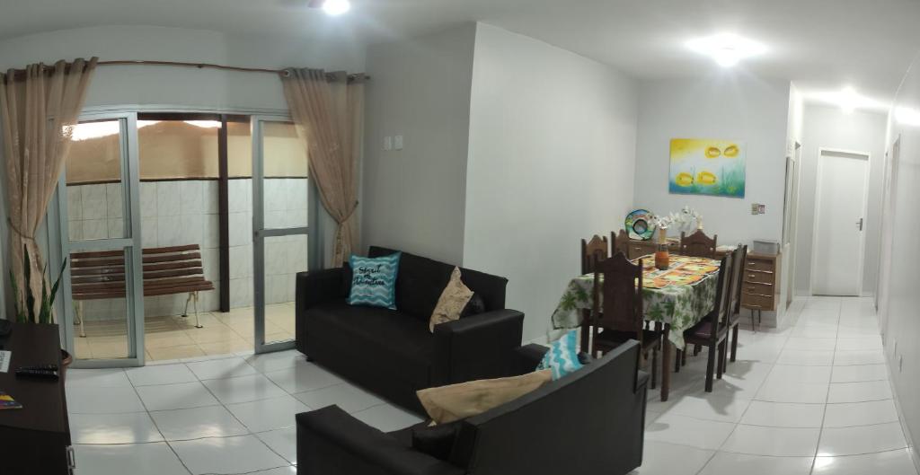 a living room with a table and a dining room at Melhor da Praia do Morro Apartamento até 10 pessoas in Guarapari