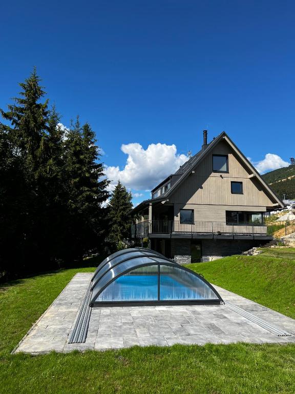 a house with a swimming pool in the grass at Chata Jestřábník in Dolní Morava