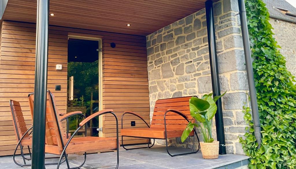 un porche con un banco y una planta en Gite La Petite Beurrerie des Ardennes, en Celles