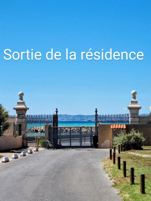 une porte vers une plage avec les mots scenic de la residence dans l'établissement Appartement T4 95m2 Plage pointe rouge 10 min stade Velodrome, à Marseille