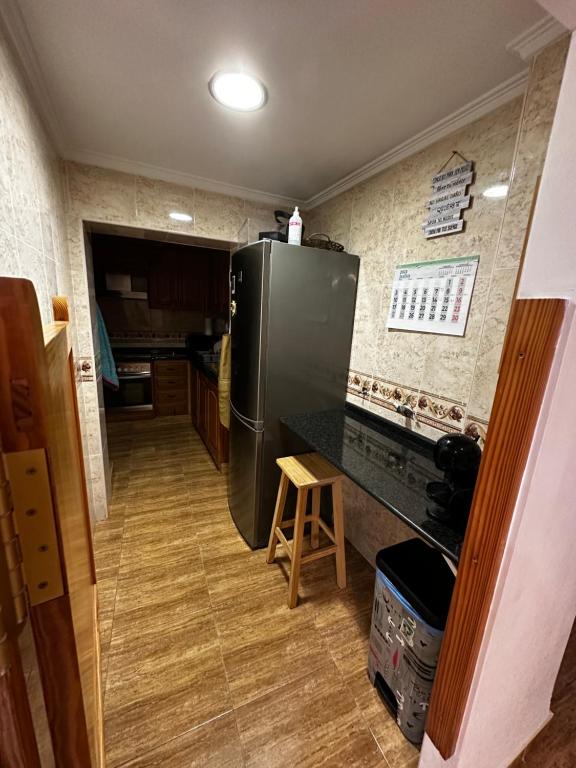 a kitchen with a black refrigerator and a wooden floor at Piso Centro de Cullera in Cullera