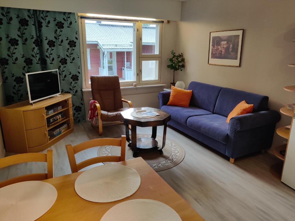 a living room with a blue couch and a table at Saimaan Kodikas in Savonlinna