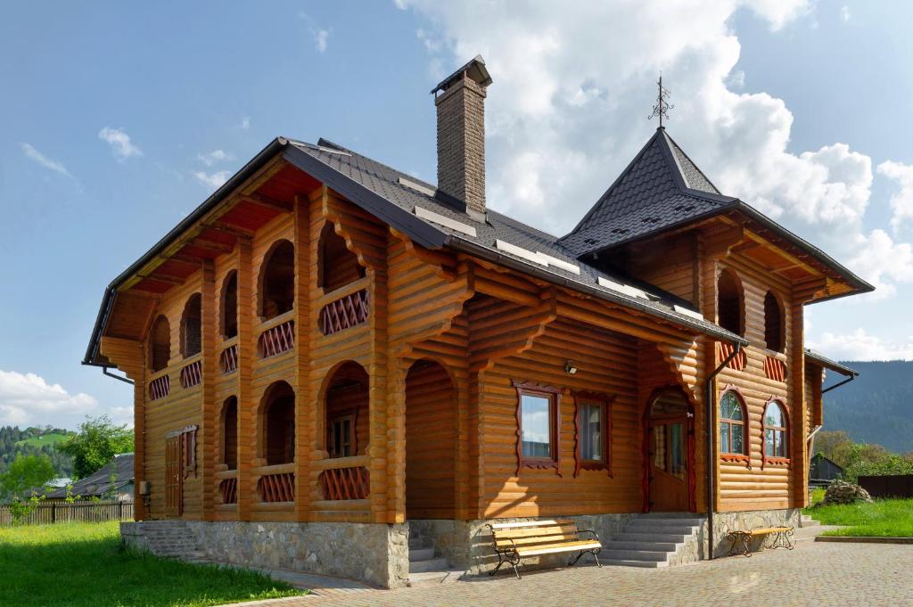 a large wooden cabin with a black roof at Гостинний двір КАРПАТІЯ, Верховина in Verkhovyna