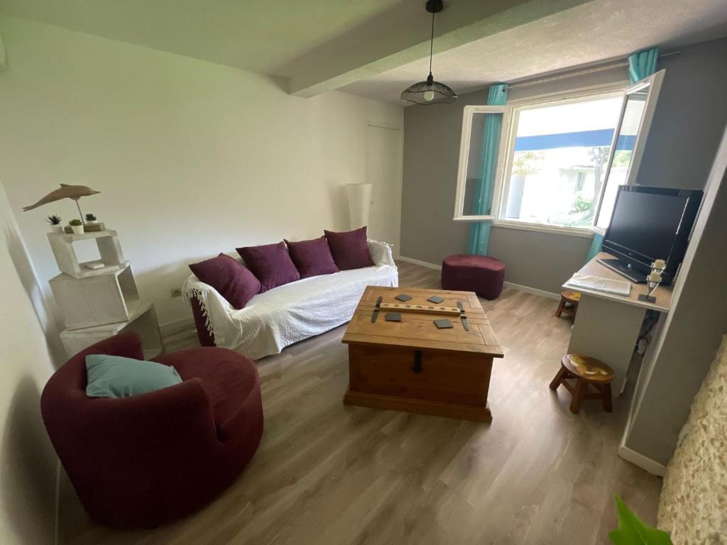 Le Cocon des SPRESS في Cers: غرفة معيشة مع أريكة وطاولة قهوة