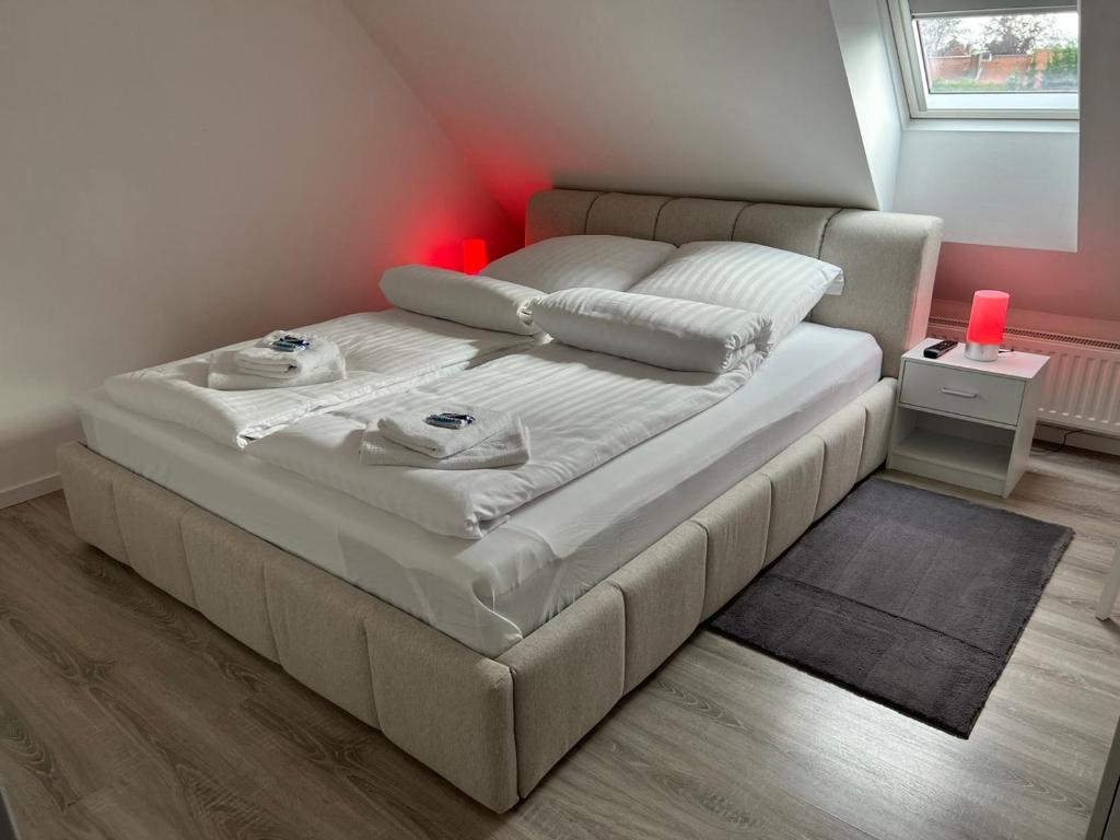 a bedroom with a large white bed with a red light at Ferienwohnung Soltau in Soltau