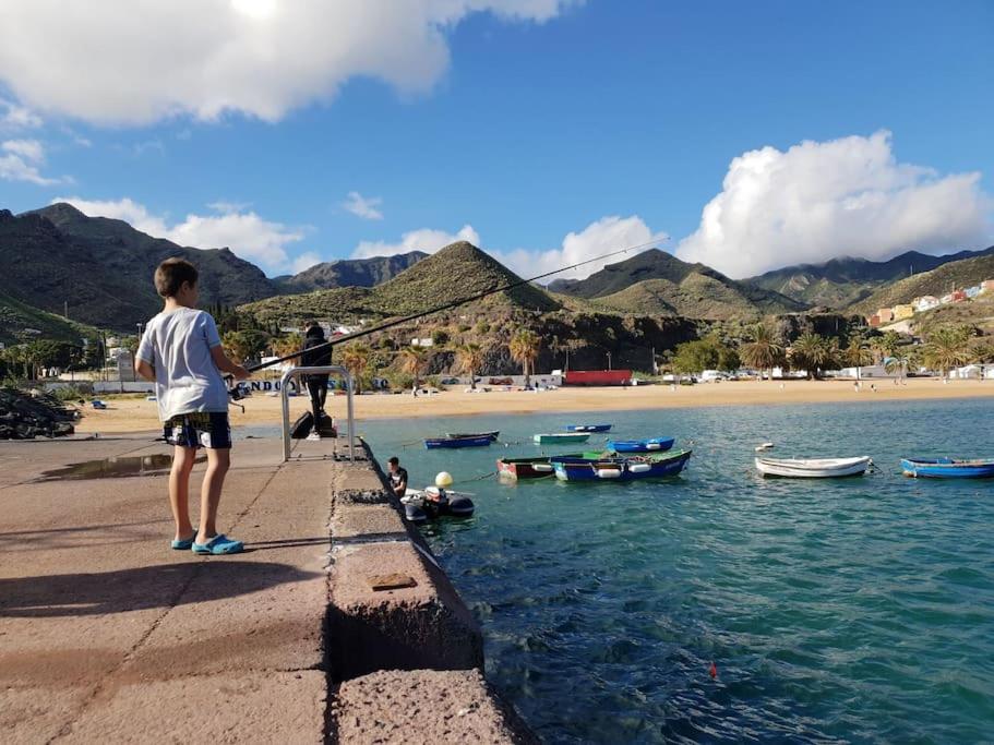 a group of people standing on a pier with boats in the water at Las Teresitas Apartment in San Andrés