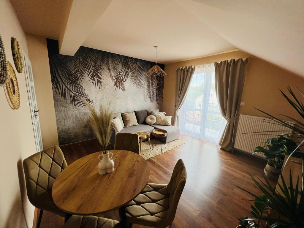 een woonkamer met een tafel en een bank bij Apartament BohoLook in Nowy Sącz