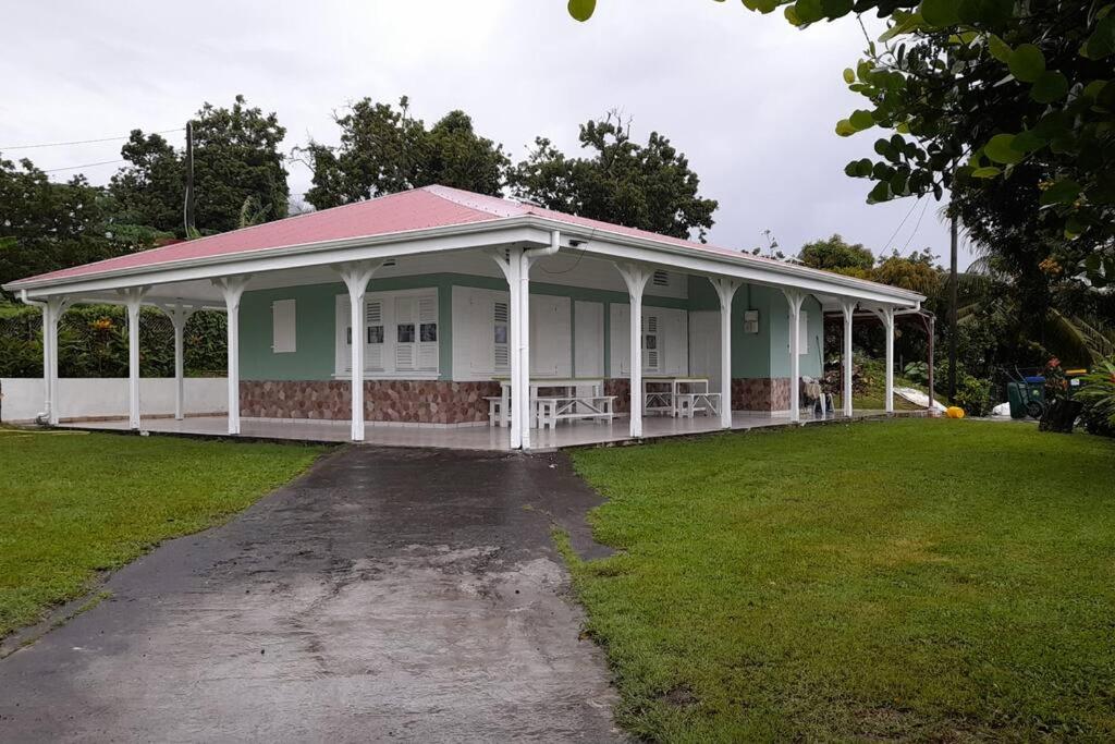 une maison blanche avec un toit rouge sur une pelouse dans l'établissement Le pain de sucre maison de campagne sainte marie, à Sainte-Marie