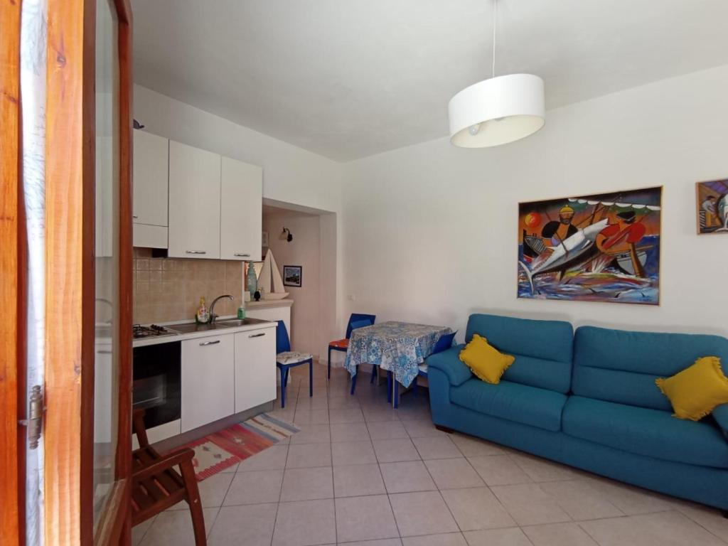 un soggiorno con divano blu e una cucina di Favignana Vacanze a Favignana