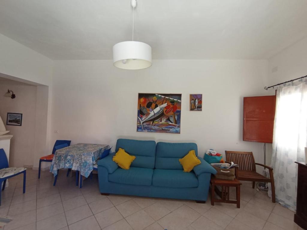 sala de estar con sofá azul y mesa en Favignana Vacanze, en Favignana