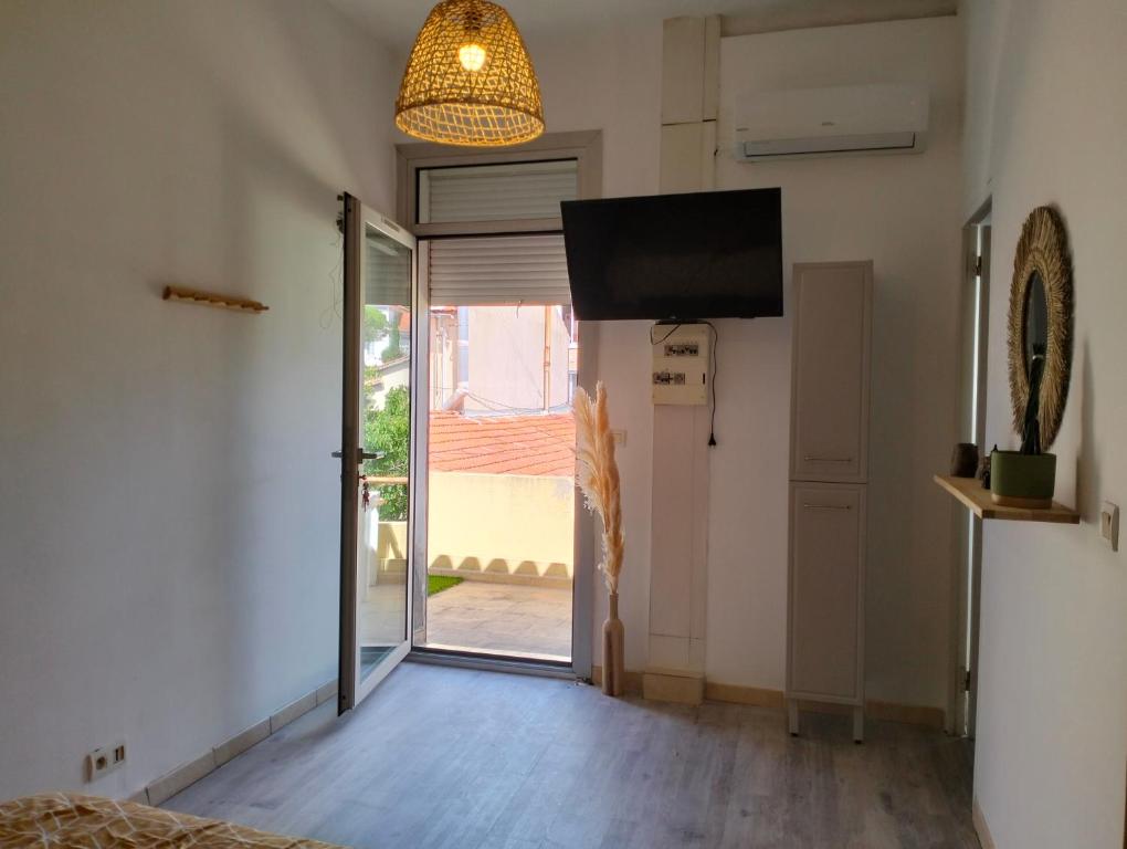 a room with a sliding glass door and a television at Logement zen love, 5 mn de la plage in Toulon