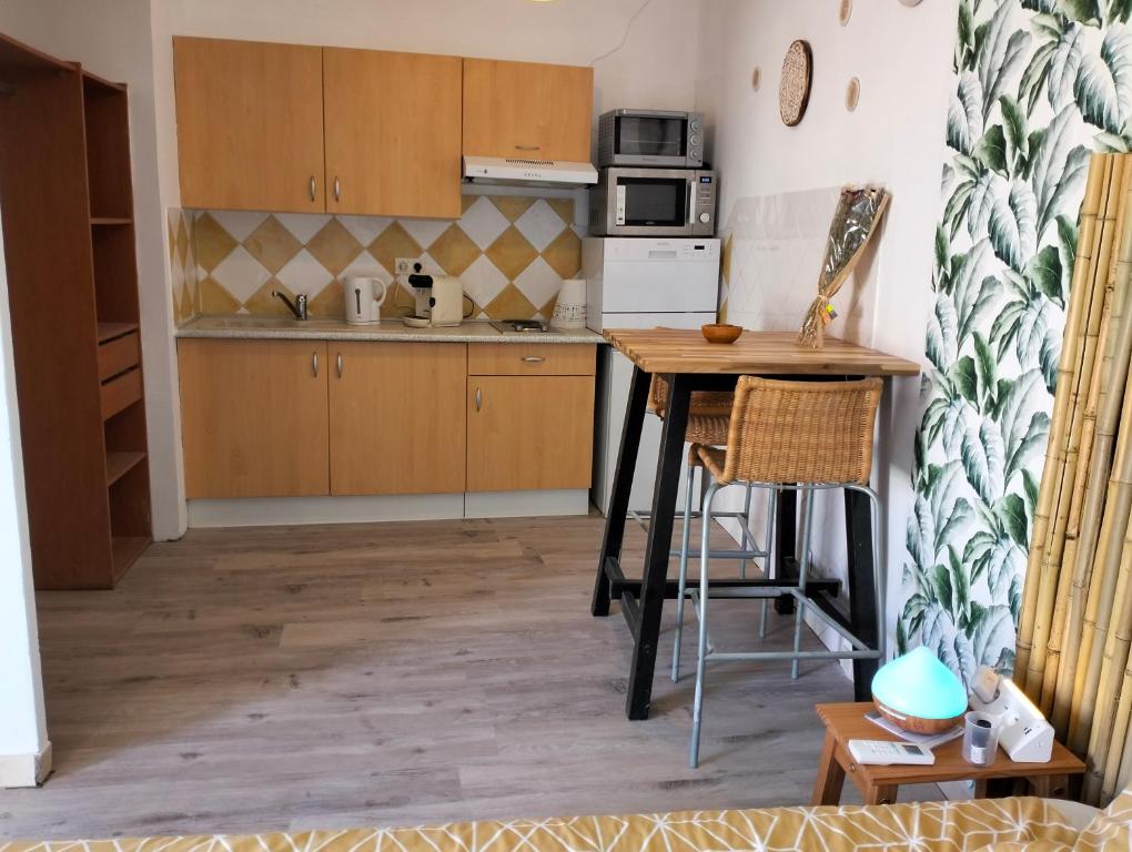 a kitchen with wooden cabinets and a table in a room at Logement zen love, 5 mn de la plage in Toulon