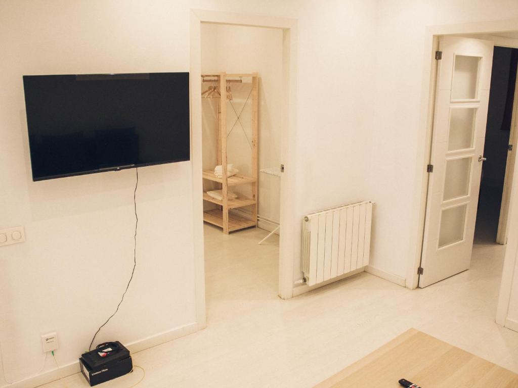 a living room with a flat screen tv hanging on a wall at Apartamento 15' Barcelona centro in Santa Coloma de Gramanet