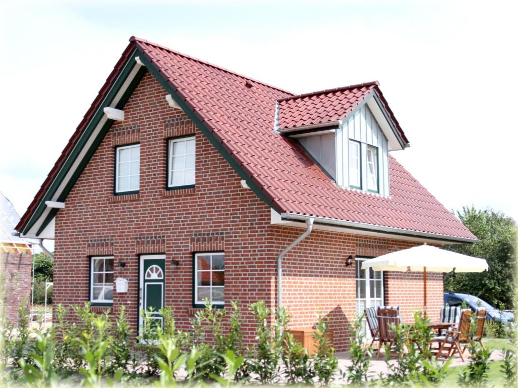 a red brick house with a red roof at Ferienhaus Pusteblume in Garrel