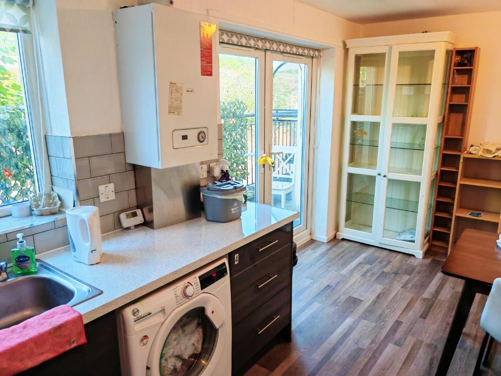 a kitchen with a sink and a washing machine at holiday home in Manchester