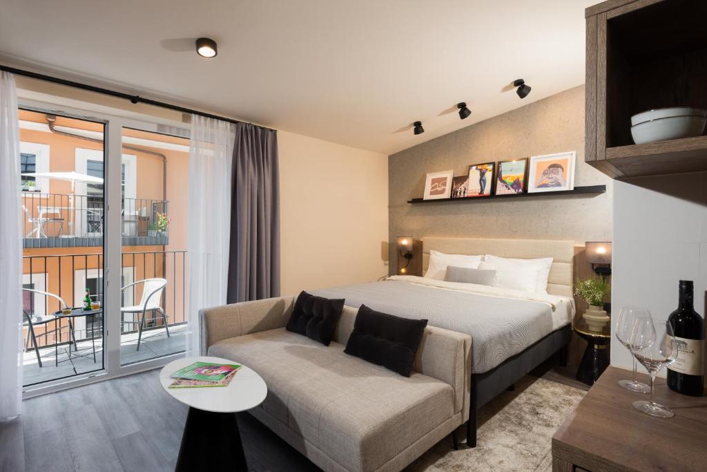 1 dormitorio con cama, sofá y balcón en master Linzergasse, en Salzburgo