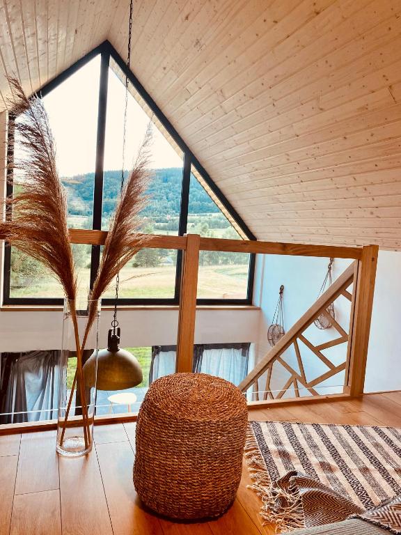 a room with a large window and a rattan chair at Domek Ostoja Góry Sowie in Łomnica
