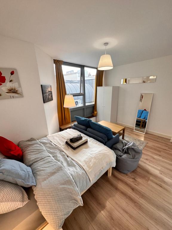 Modern 2 bedroom flat next to Liverpool Street في لندن: غرفة نوم بسرير واريكة