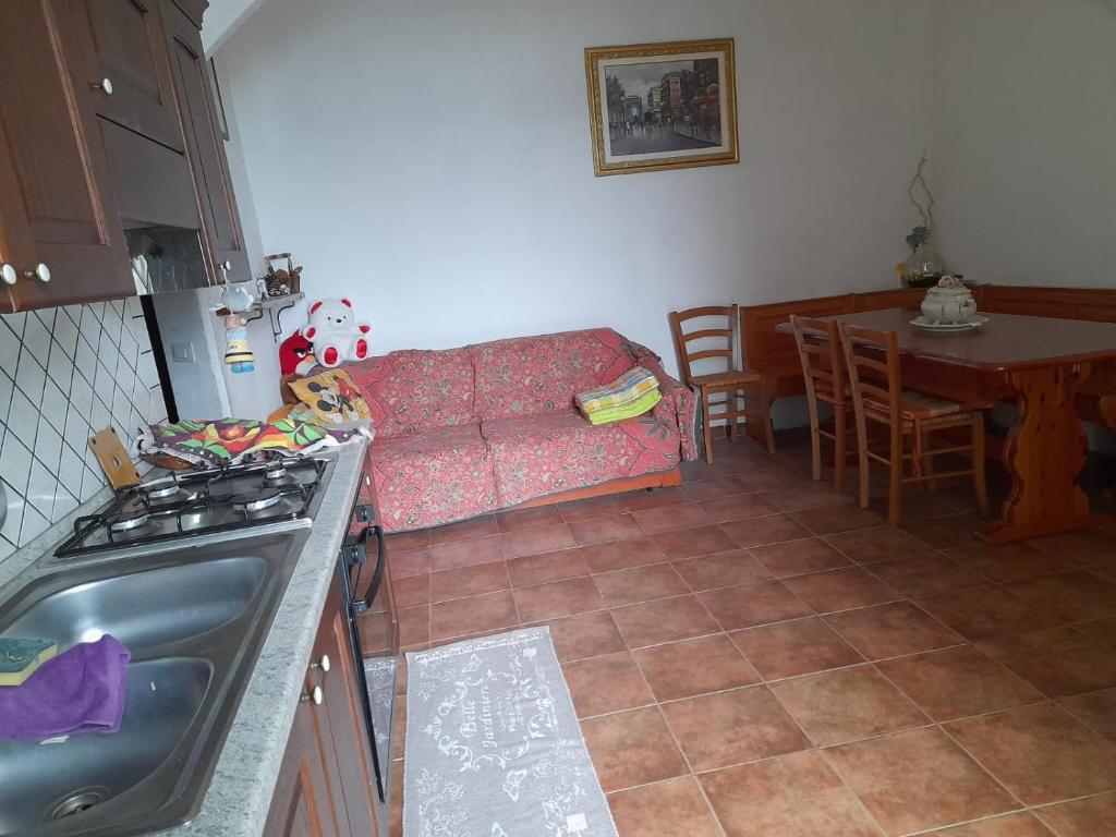 una cucina e un soggiorno con divano e tavolo di Casa Vacanza Giacu ad Arzana