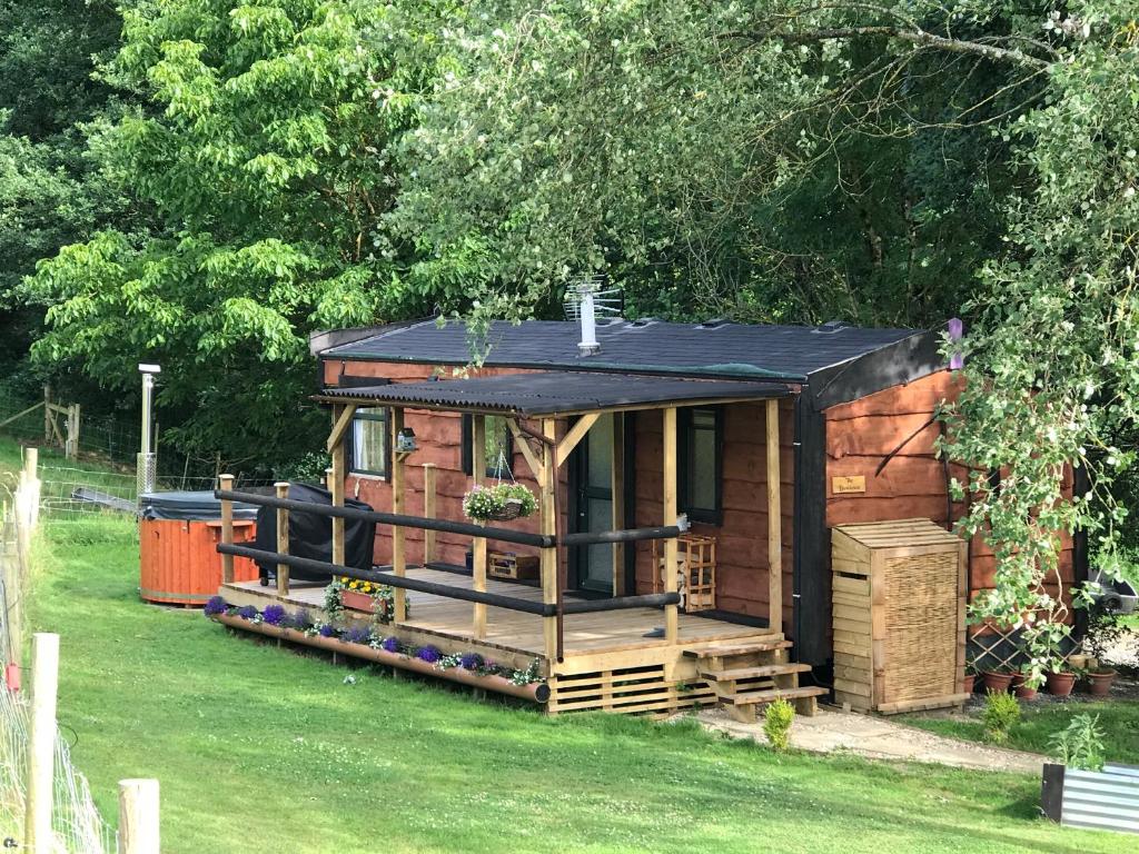 een kleine houten hut in een tuin met bomen bij The Vobster Inn in Radstock